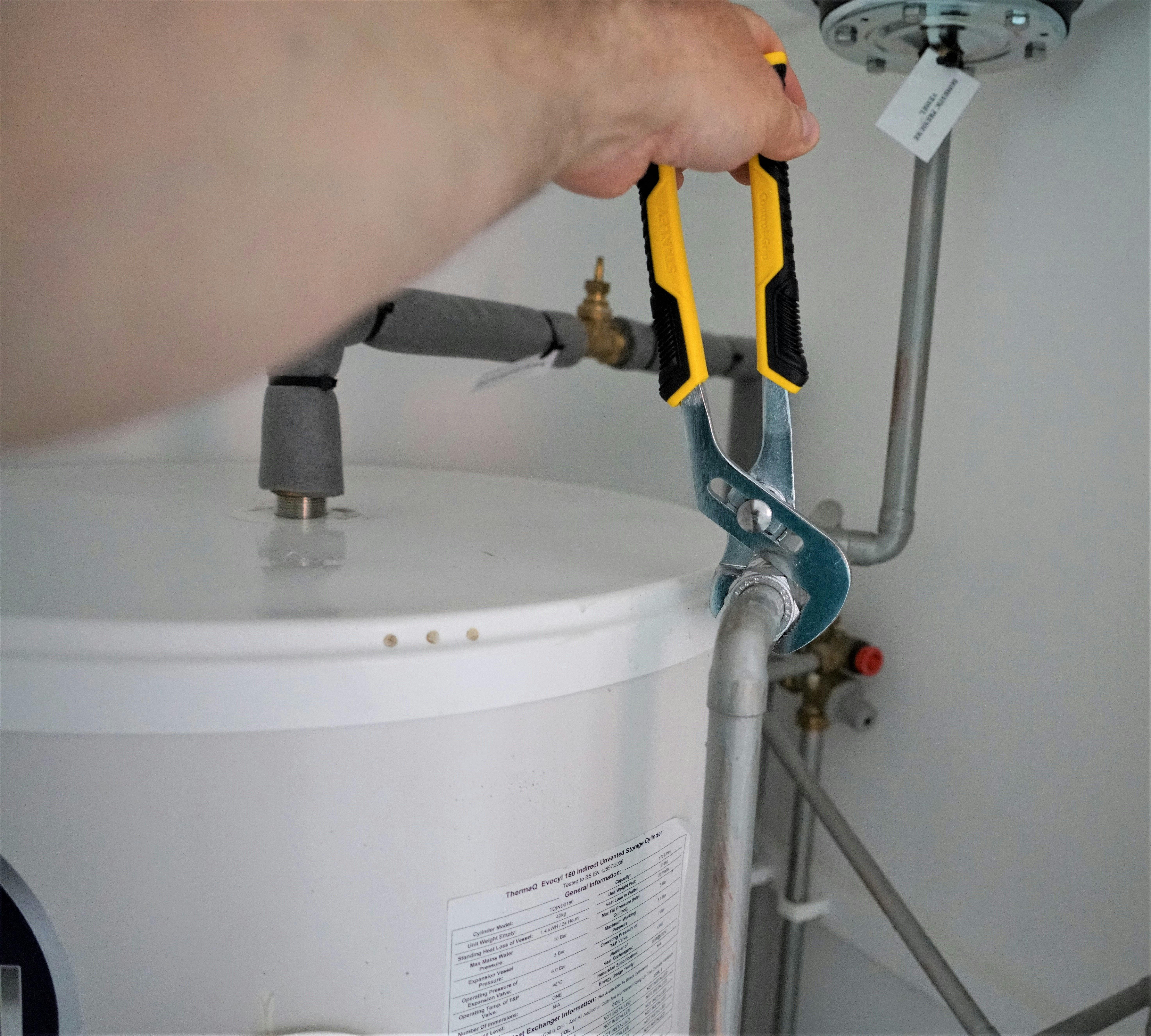 Professional plumber working on water heater installation